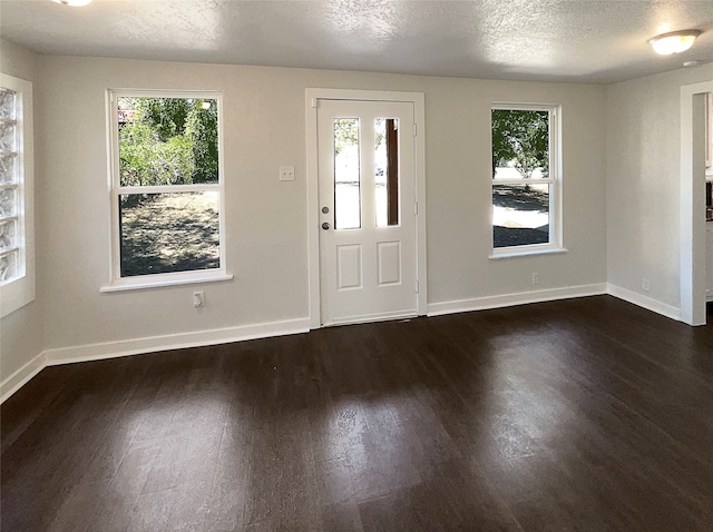 entrance foyer with a healthy amount of sunlight, dark wood-type flooring, and a textured ceiling