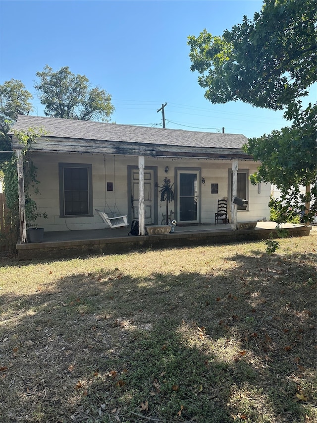 rear view of property with a lawn and a porch