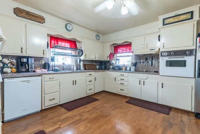 kitchen featuring a healthy amount of sunlight, white appliances, and white cabinets