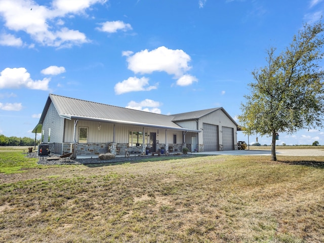 view of front of house with a garage, covered porch, and a front lawn