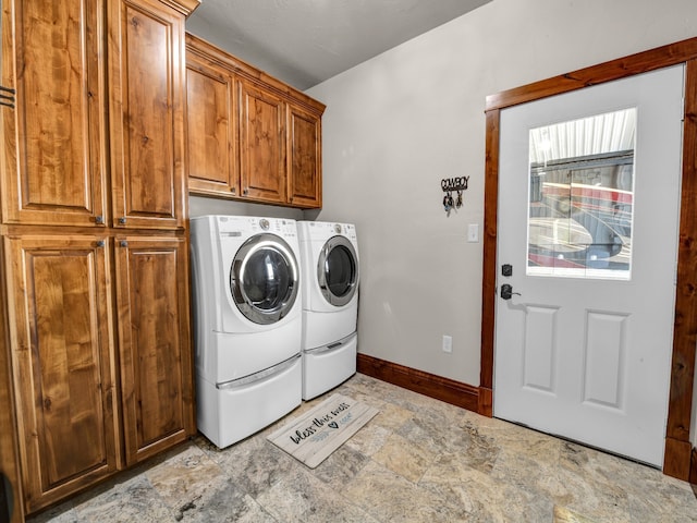 clothes washing area featuring cabinets and washing machine and clothes dryer