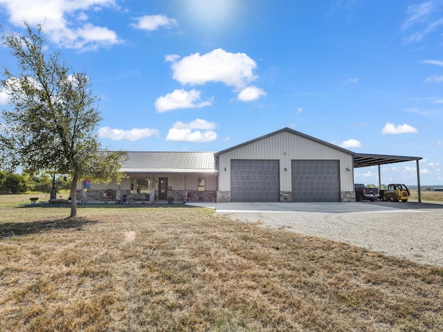 view of front facade with a carport, a porch, a garage, and a front lawn