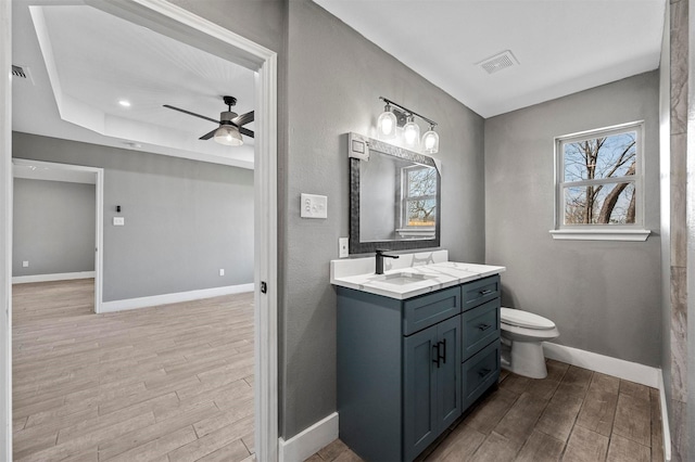 bathroom featuring baseboards, visible vents, a ceiling fan, toilet, and wood finished floors