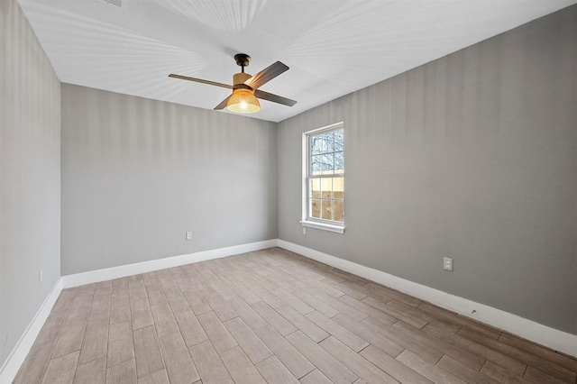 unfurnished room featuring ceiling fan, baseboards, and wood finished floors