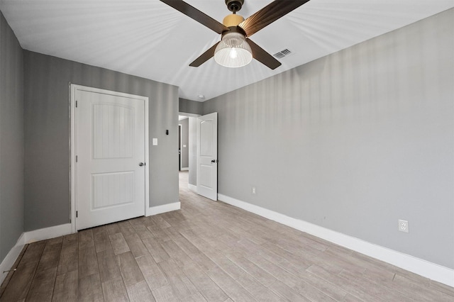 unfurnished bedroom with visible vents, ceiling fan, baseboards, and wood finished floors