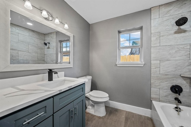 bathroom with toilet, plenty of natural light, baseboards, and wood finished floors