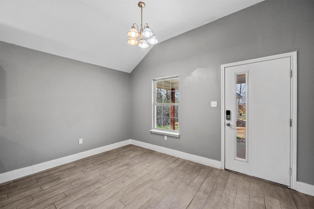 interior space featuring lofted ceiling, a notable chandelier, baseboards, and wood finished floors