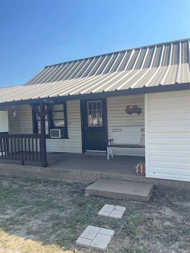 property entrance with cooling unit and a porch