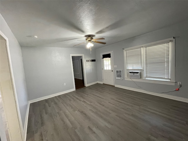 interior space with dark wood-type flooring, ceiling fan, cooling unit, and a textured ceiling