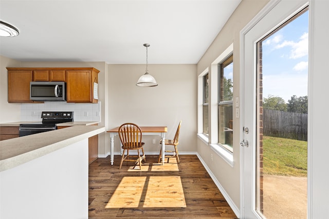 kitchen featuring decorative backsplash, dark hardwood / wood-style flooring, electric range, and a healthy amount of sunlight