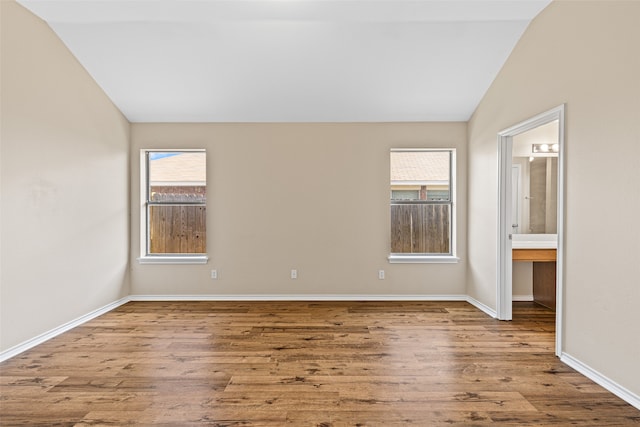 empty room featuring vaulted ceiling and light hardwood / wood-style floors