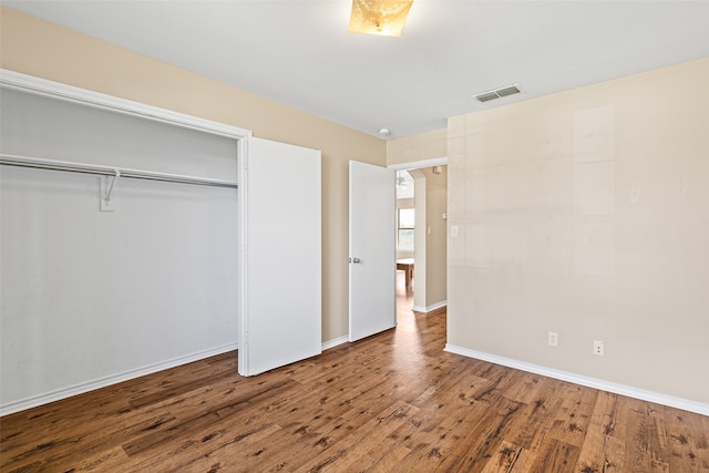 unfurnished bedroom with hardwood / wood-style flooring and a closet