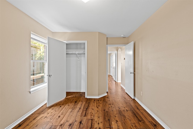 unfurnished bedroom featuring a closet and hardwood / wood-style floors