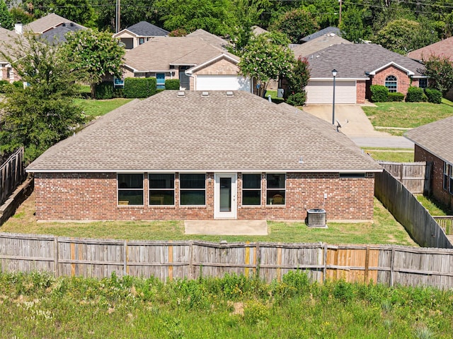 1108 E E Park, Lindale, TX 75771 - back of property with brick siding, a shingled roof, central AC unit, and a garage