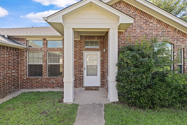 entrance to property with a lawn