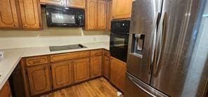 149 NW Suzanne Ter, Burleson, TX 76028 - kitchen with black appliances, brown cabinetry, and light countertops