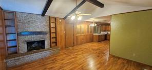 149 NW Suzanne Ter, Burleson, TX 76028 - unfurnished living room with wood finished floors, a ceiling fan, and a fireplace