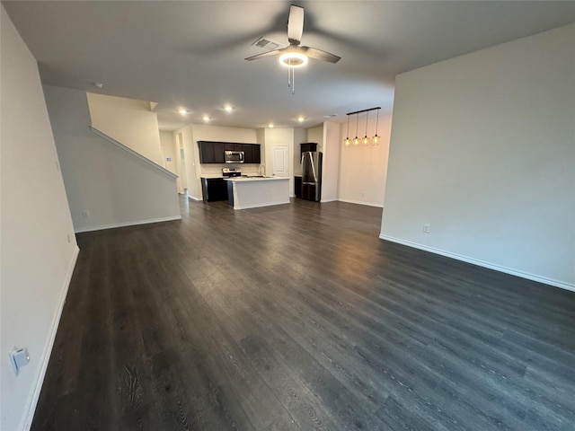 unfurnished living room featuring ceiling fan and dark wood-type flooring