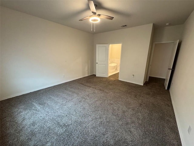 unfurnished bedroom featuring ceiling fan, ensuite bathroom, and dark carpet