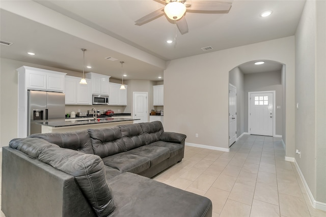 tiled living room with ceiling fan