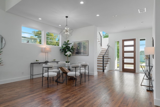 dining area featuring dark wood-type flooring and a chandelier