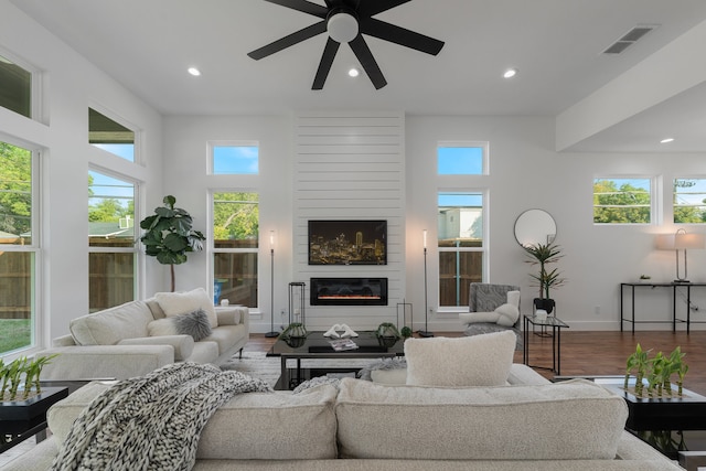 living room with plenty of natural light, hardwood / wood-style flooring, and ceiling fan