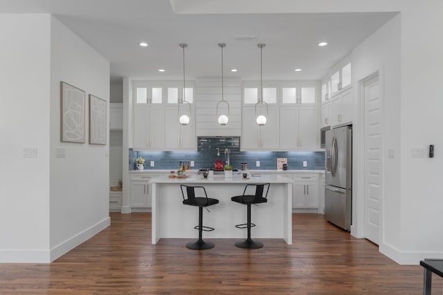 kitchen featuring dark hardwood / wood-style floors, white cabinets, stainless steel refrigerator with ice dispenser, and a kitchen island with sink