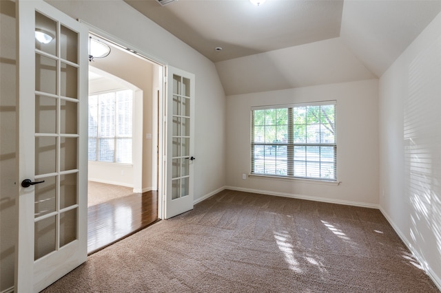 carpeted spare room with french doors and lofted ceiling