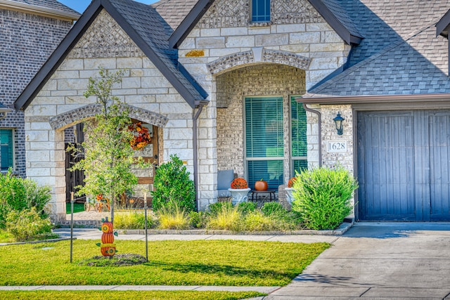 property entrance featuring a garage and a lawn