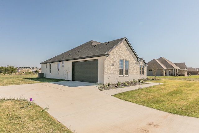 view of home's exterior featuring central AC unit, a lawn, and a garage