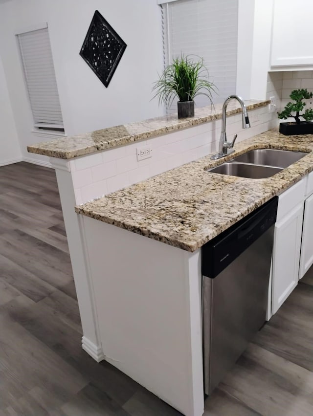 kitchen with dark wood-type flooring, white cabinetry, stainless steel dishwasher, and sink