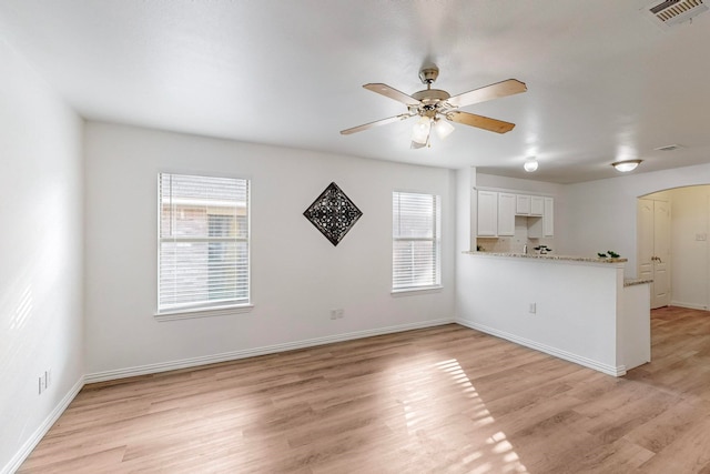 unfurnished living room with light hardwood / wood-style floors, a healthy amount of sunlight, and ceiling fan