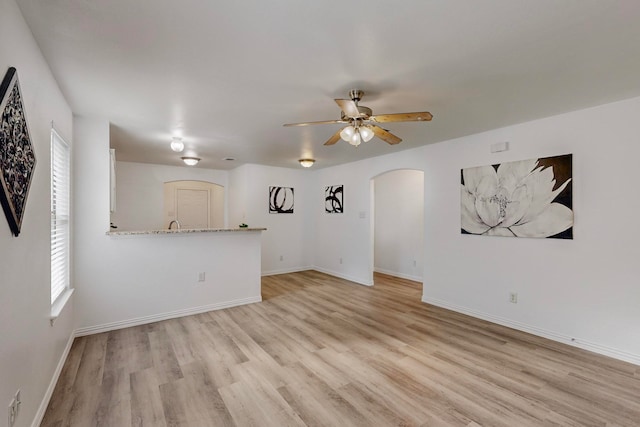 unfurnished living room featuring light wood-type flooring and ceiling fan