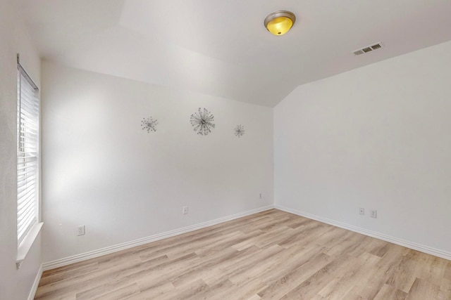 unfurnished room featuring light hardwood / wood-style floors, plenty of natural light, and lofted ceiling