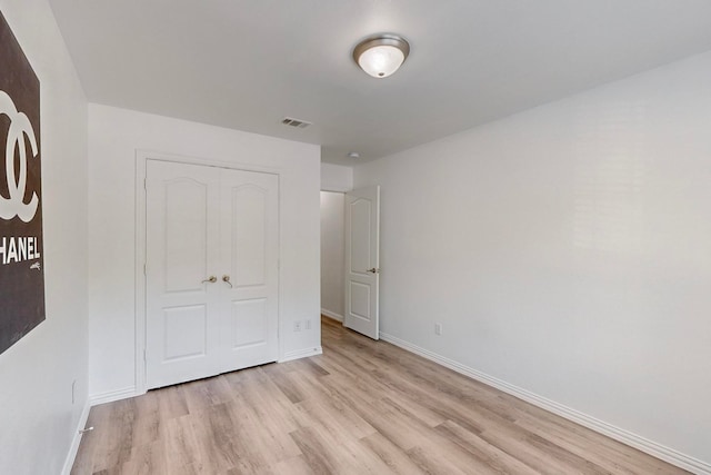 unfurnished bedroom featuring light hardwood / wood-style floors and a closet