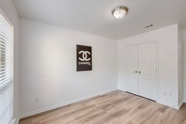 unfurnished bedroom featuring a closet and light wood-type flooring