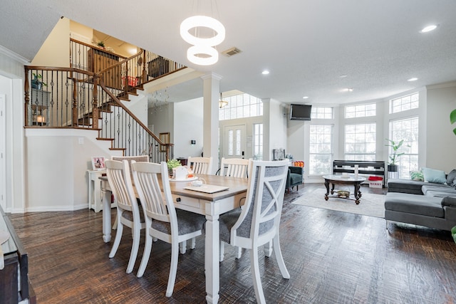 dining space with ornate columns, crown molding, a textured ceiling, and dark hardwood / wood-style floors