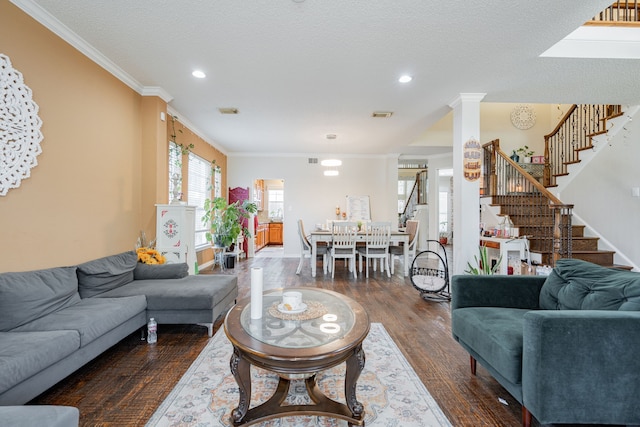 living room featuring a textured ceiling, ornate columns, crown molding, and dark hardwood / wood-style floors