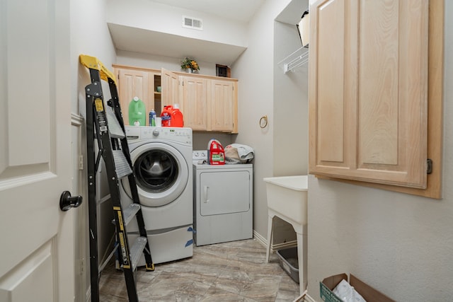 washroom featuring cabinets and separate washer and dryer