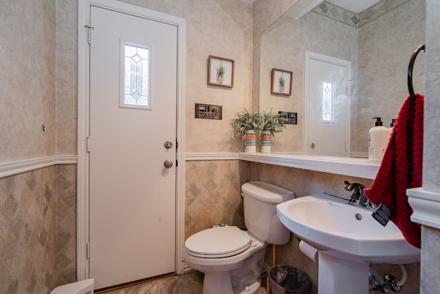 bathroom with toilet and tile walls