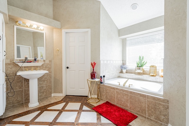 bathroom featuring tiled tub and lofted ceiling