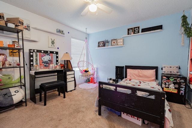 bedroom featuring ceiling fan, light carpet, and a textured ceiling