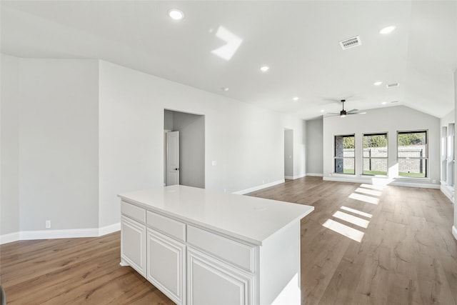 interior space with light wood-type flooring, ceiling fan, and vaulted ceiling