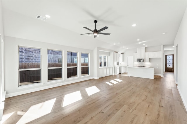 unfurnished living room featuring lofted ceiling, ceiling fan, and light hardwood / wood-style floors