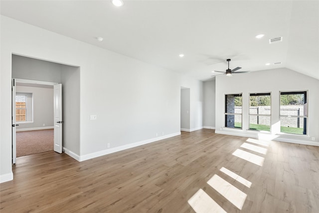 unfurnished living room with vaulted ceiling, ceiling fan, plenty of natural light, and light hardwood / wood-style floors