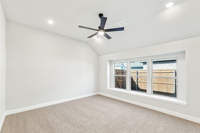 unfurnished room featuring ceiling fan, vaulted ceiling, and carpet flooring