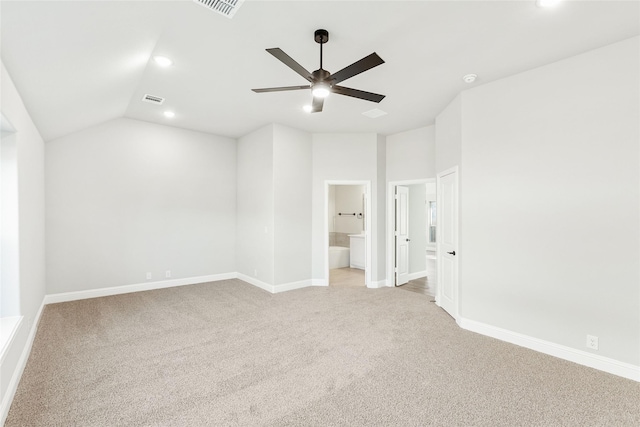 unfurnished bedroom featuring vaulted ceiling, light carpet, connected bathroom, and ceiling fan