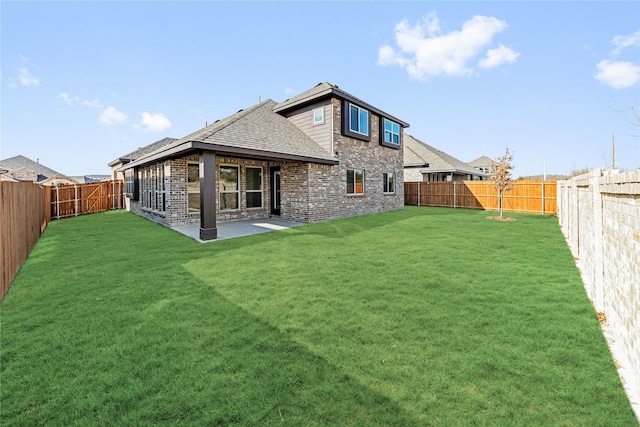 rear view of house with a yard and a patio area