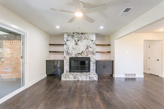 unfurnished living room with a fireplace, ceiling fan, and dark hardwood / wood-style flooring