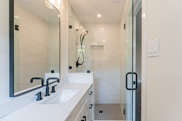 bathroom featuring tile patterned floors, vanity, and a shower with shower door